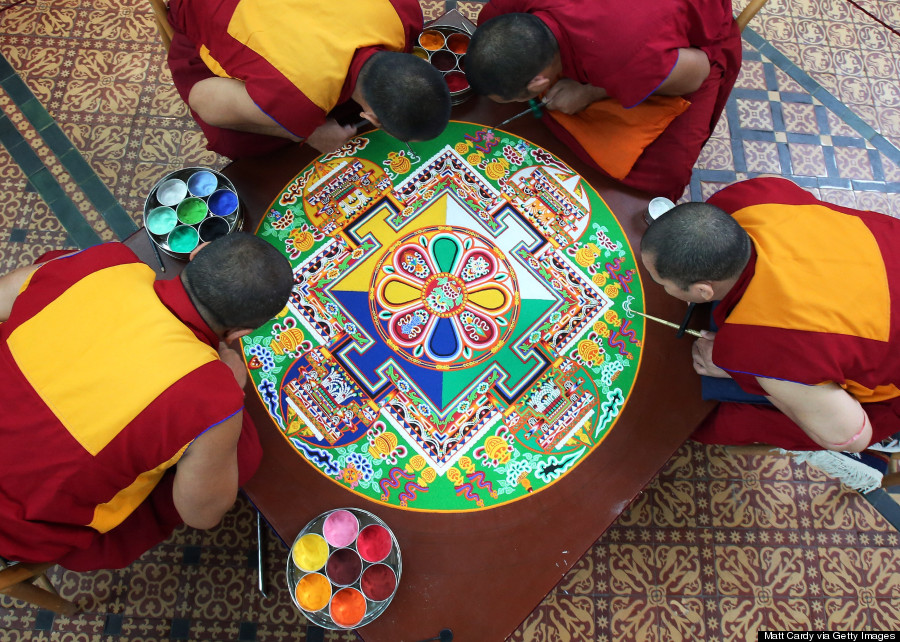 SALISBURY, ENGLAND - OCTOBER 03: Tibetan Monks from the Tashi Lhunpo Monastery , (clockwise from top) Ven Lobzang Thokmed, Kachen Namgyal, Kachen Lobzang Tuskhor and Kachen Choedrak complete a Chenrezig Sand Mandala in Salisbury Cathedrals Chapter House on October 3, 2013 in Salisbury, England. The monks, who started the painstaking process of creating the sand mandela with millions of grains of coloured sand on Monday, will end it tomorrow in a destruction ceremony and procession to the River Avon. The monks who currently live in exile in India are visiting various places in the UK and Europe and will complete two more sand mandelas - which are an artistic tradition of Tibetan Buddhism and are a symbolic picture of the universe representing an imaginary palace - before returning home to their monastery in late November. (Photo by Matt Cardy/Getty Images)